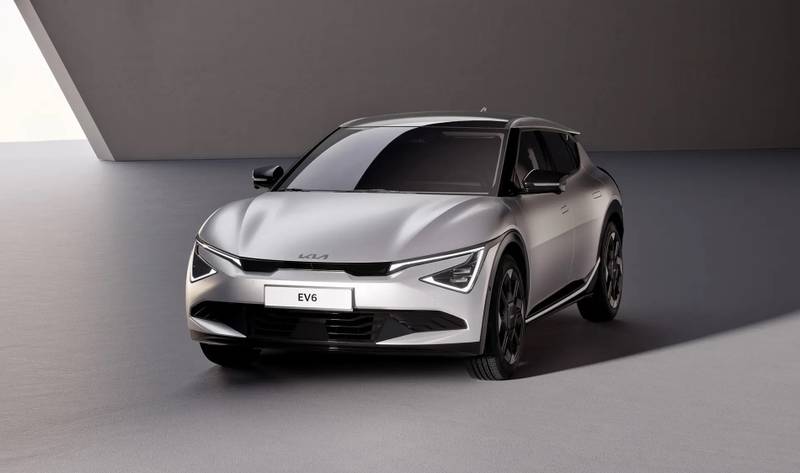 A silver Kia EV6 electric vehicle with its updated 2024 facelift, parked in a modern, minimalist indoor space with soft lighting.