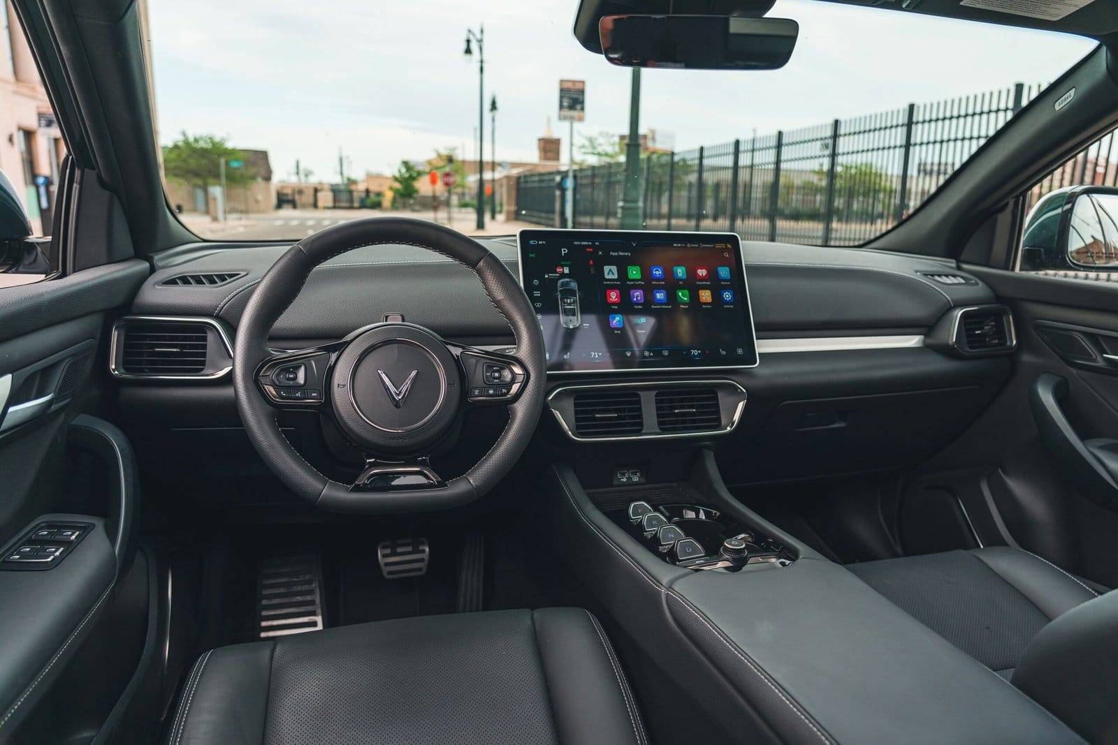 Dashboard and steering wheel of the Vinfast VF8 electric vehicle showing the infotainment touchscreen and black leather interior