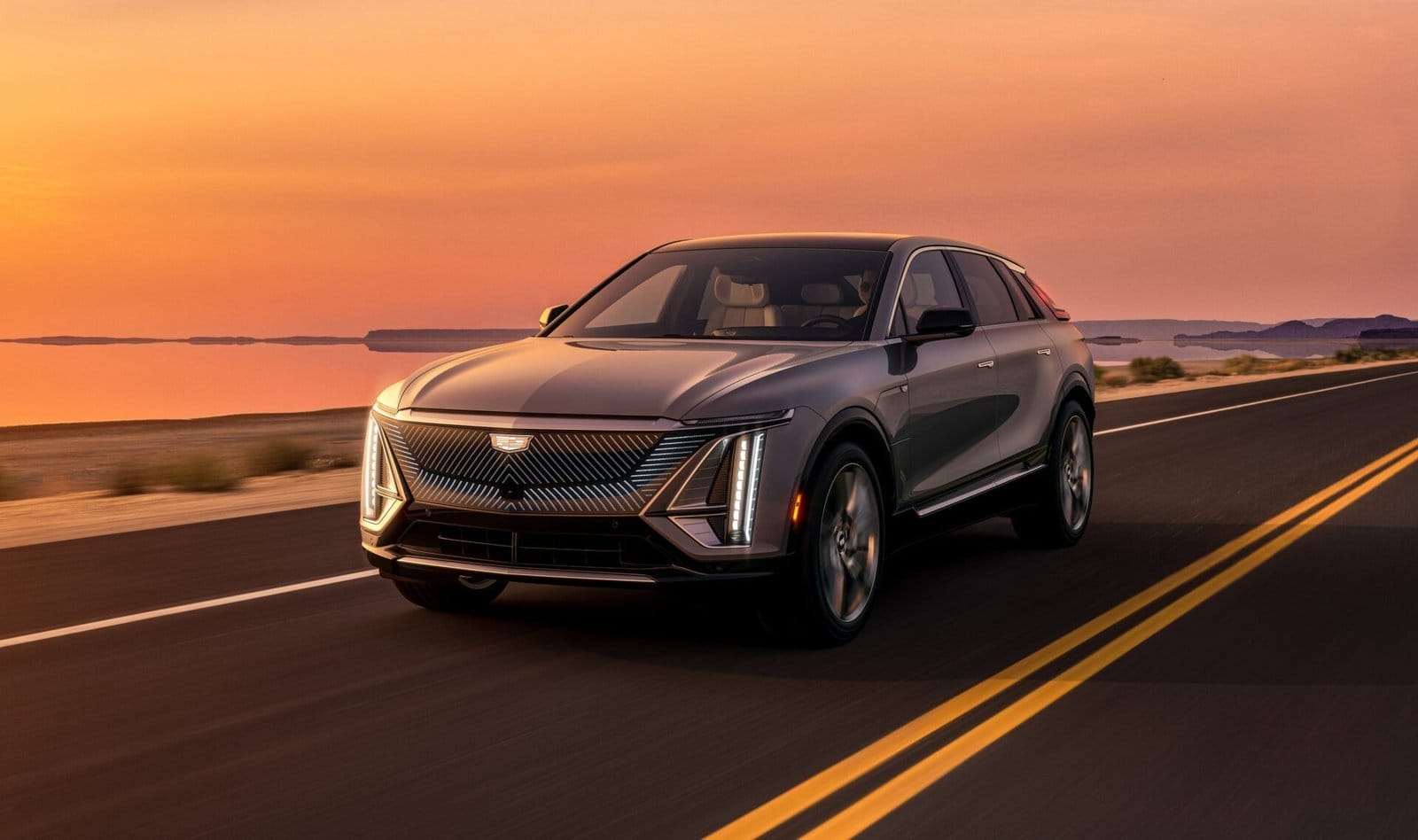 Cadillac Lyriq Electric Vehicle Driving on a Desert Road at Sunset 1