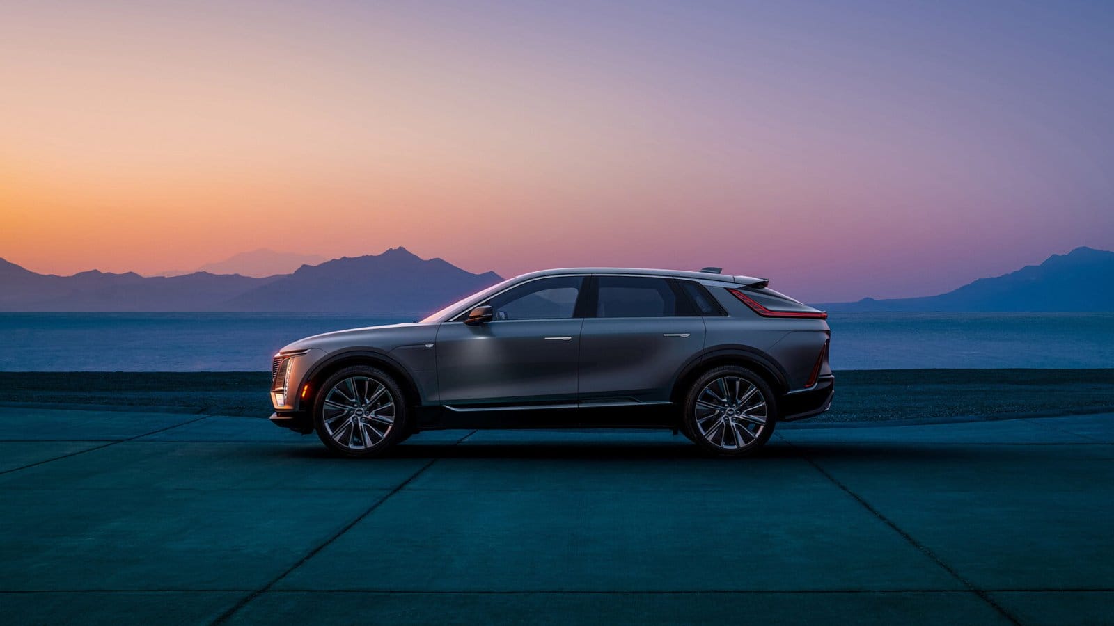 cadillac lyriq electric vehicle side view sunset lake