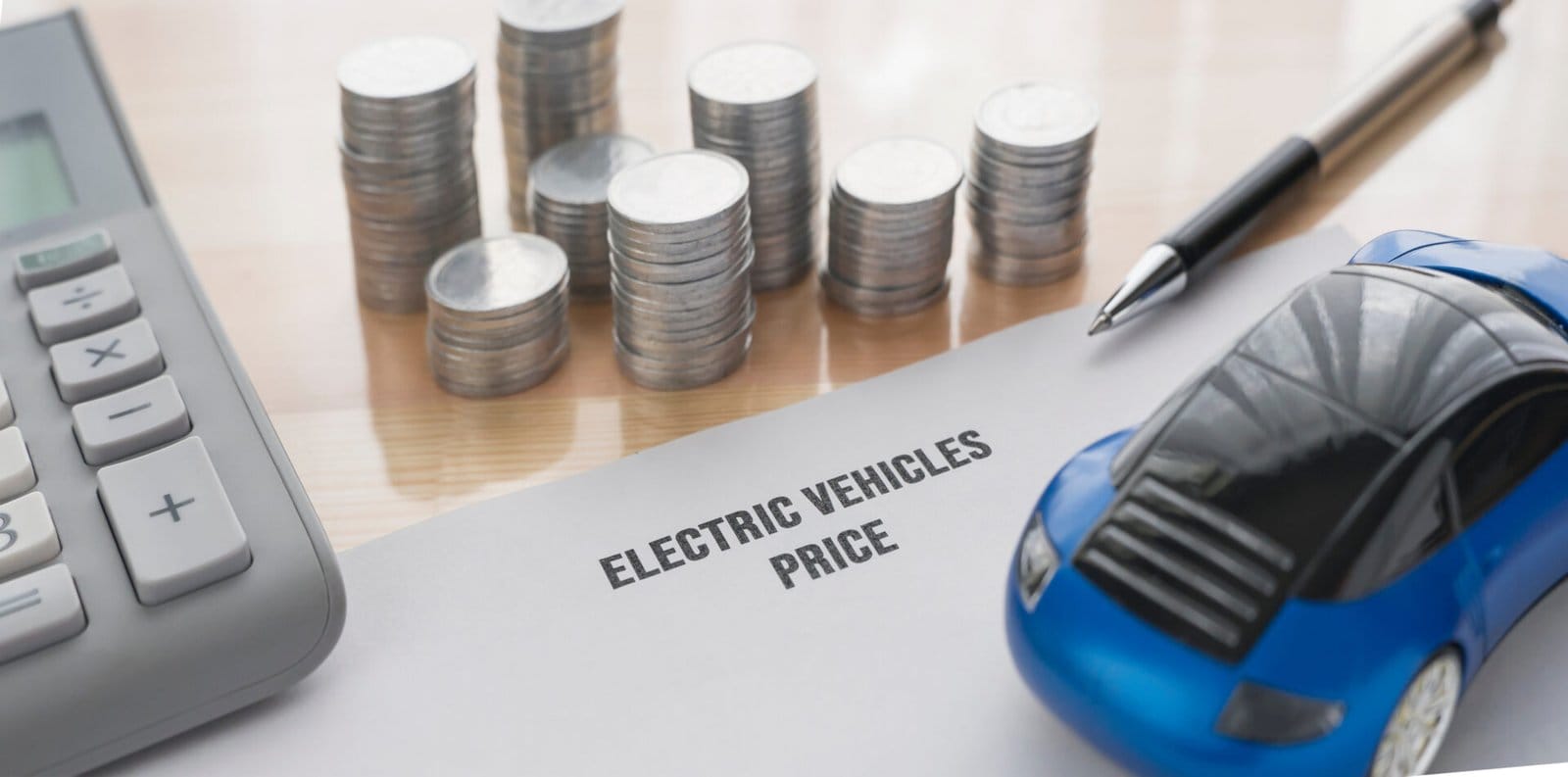 Miniature of an electric vehicle, pen and stacked coins representing the price of an electric vehicle. Paper written price of electric vehicles.