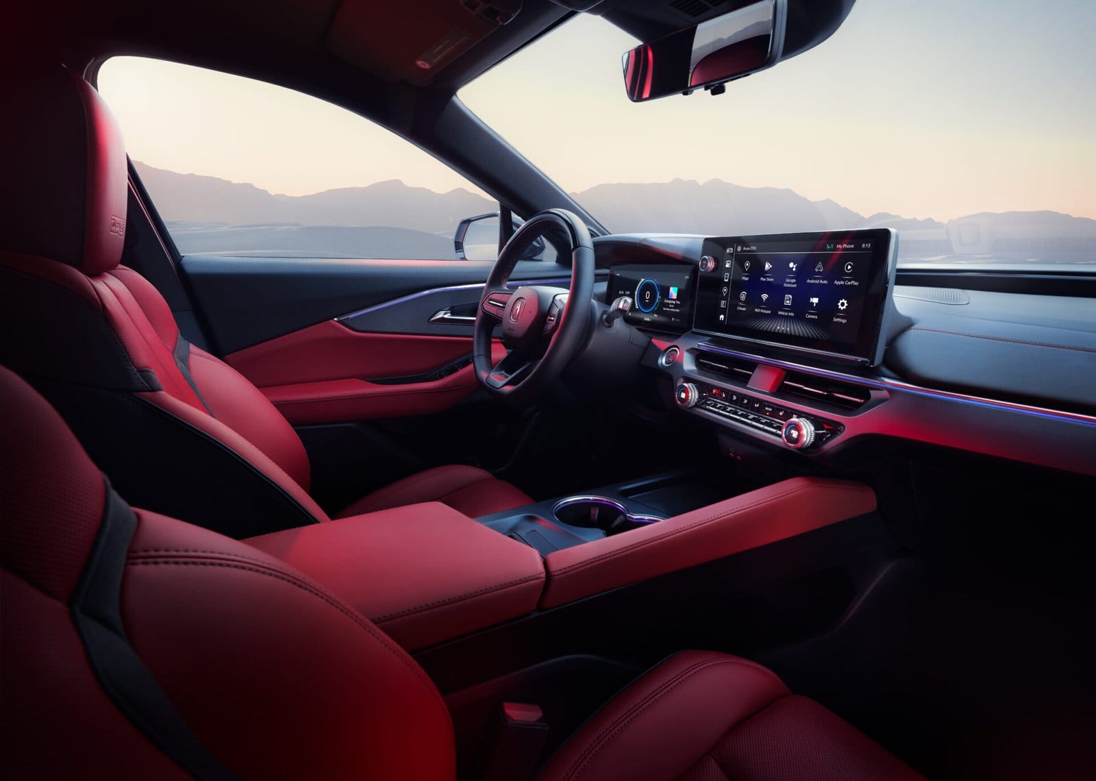 Interior of the Acura ZDX electric vehicle showcasing red leather seats, a digital dashboard, and a large infotainment screen with a scenic mountain view through the windows.