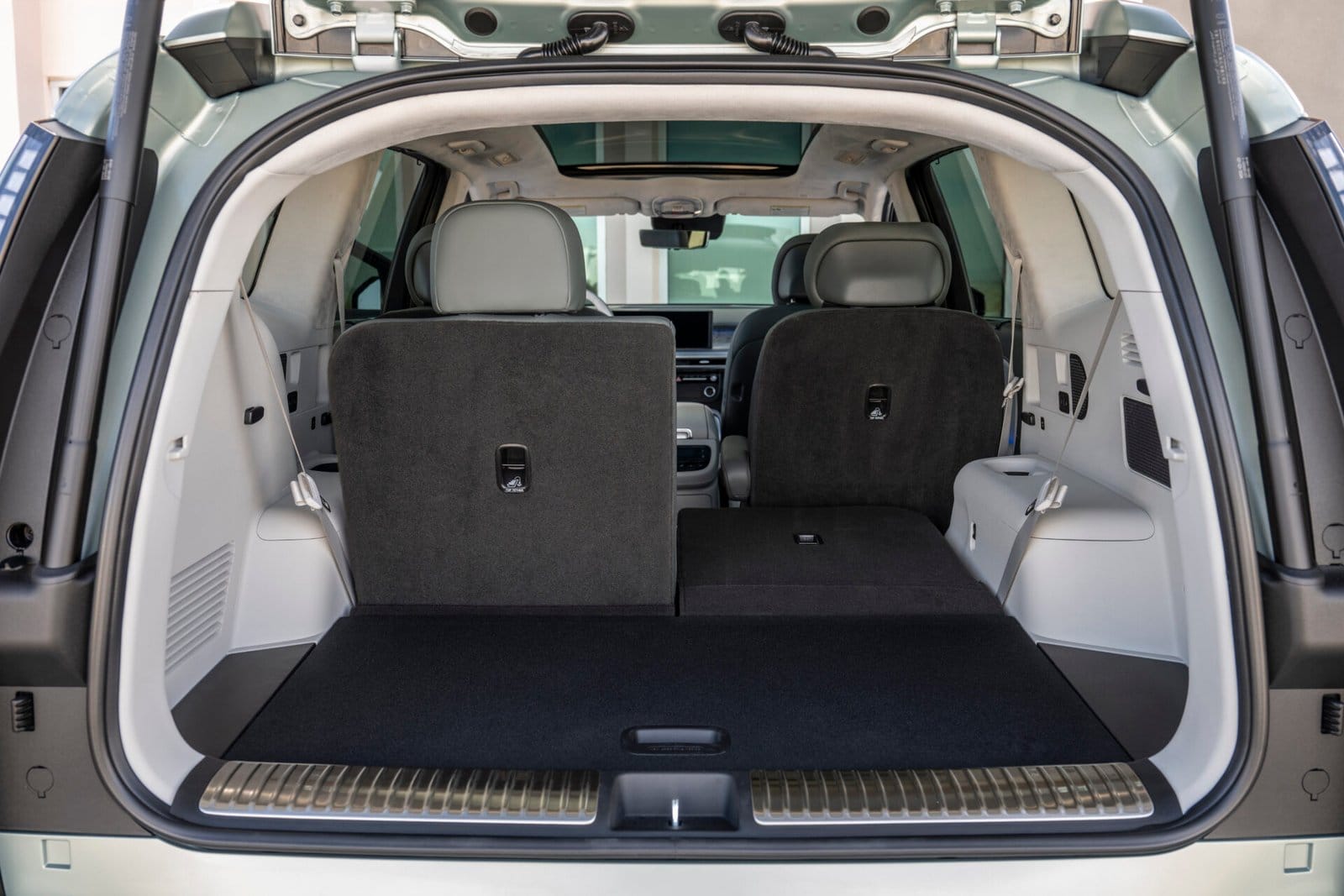 The open cargo area of the Hyundai Ioniq 9 electric vehicle, showing foldable rear seats with one side folded down to extend storage space.