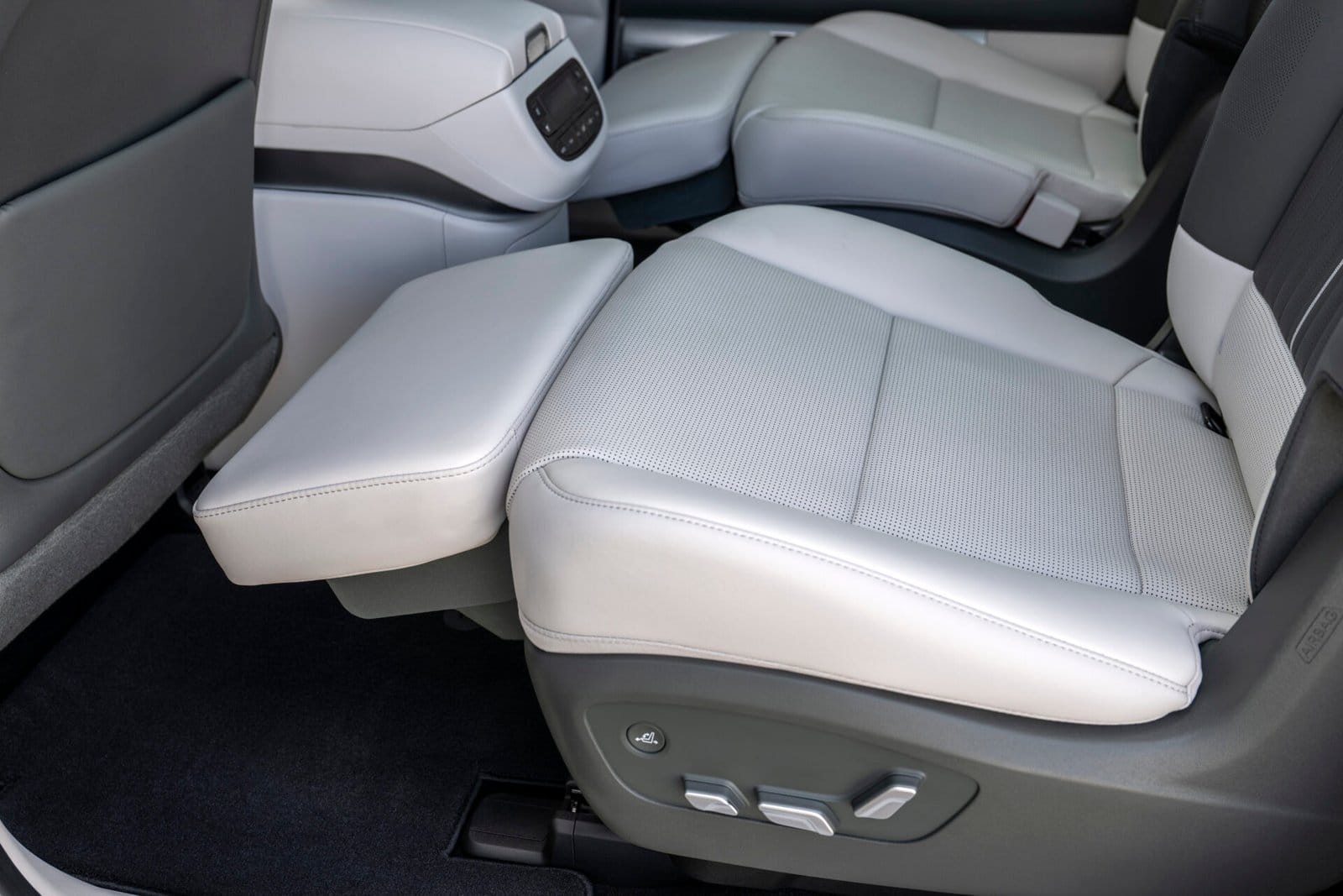 Close-up of a reclining front passenger seat in the Hyundai Ioniq 9 electric vehicle, upholstered in light gray leather with adjustable controls on the side.