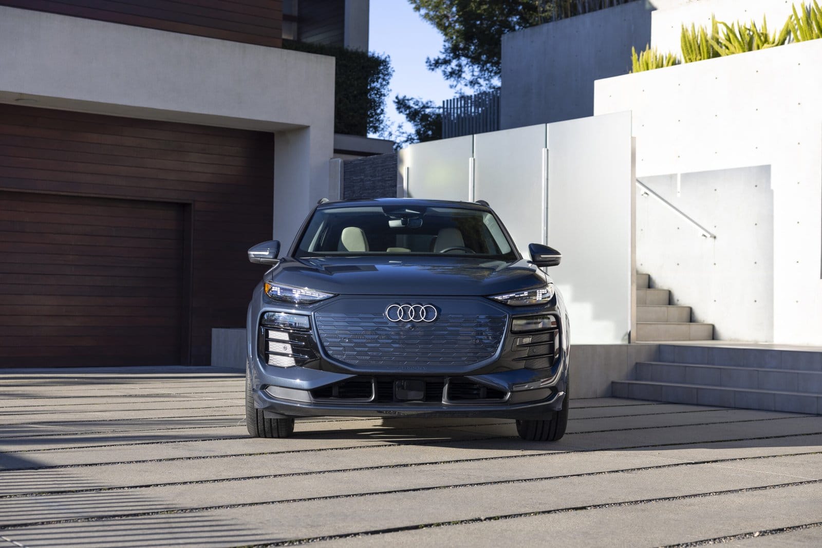 Front view of blue Audi Q6 electric SUV parked in a modern driveway