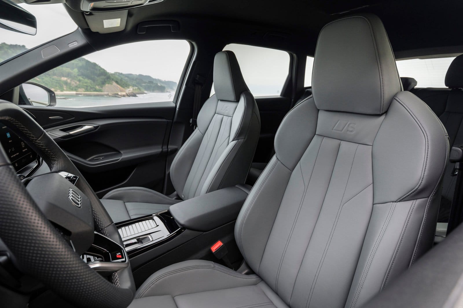 Audi Q6 electric vehicle cabin showing close-up of front sport seats and steering
