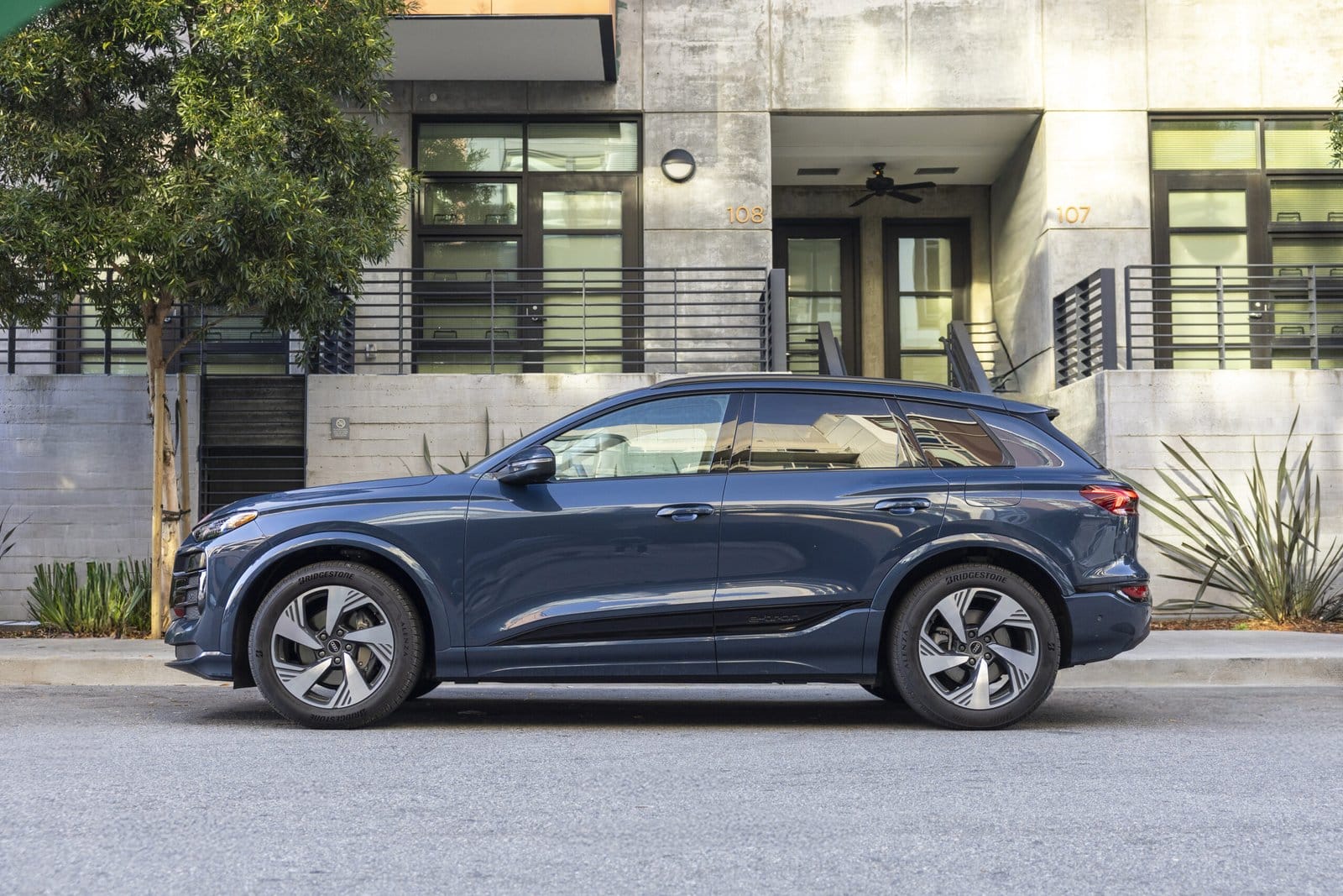 Blue Audi Q6 electric vehicle side view parked in urban neighborhood