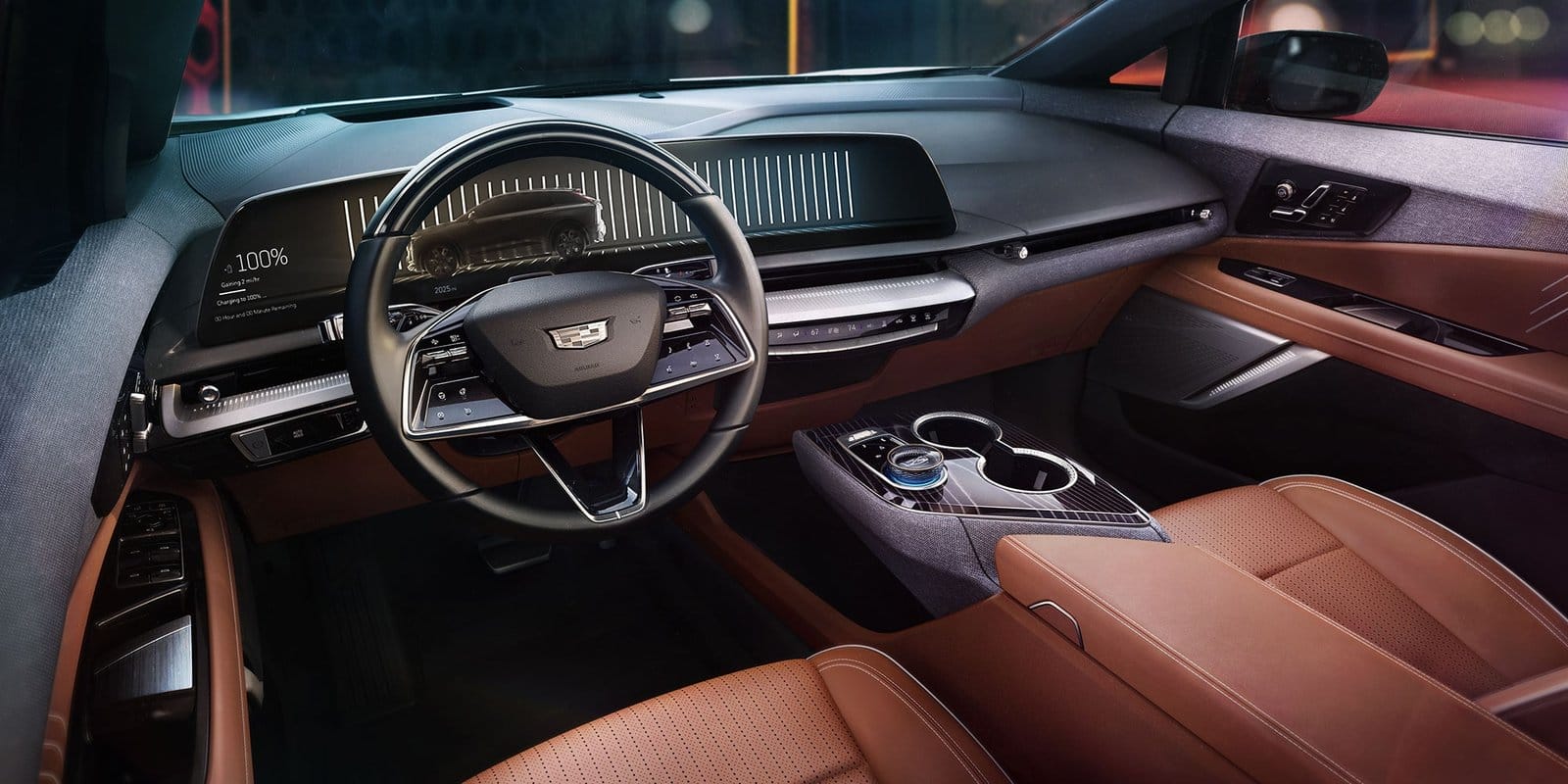 Steering wheel and front cabin of the 2025 Cadillac Optiq electric vehicle with brown leather seats and modern display