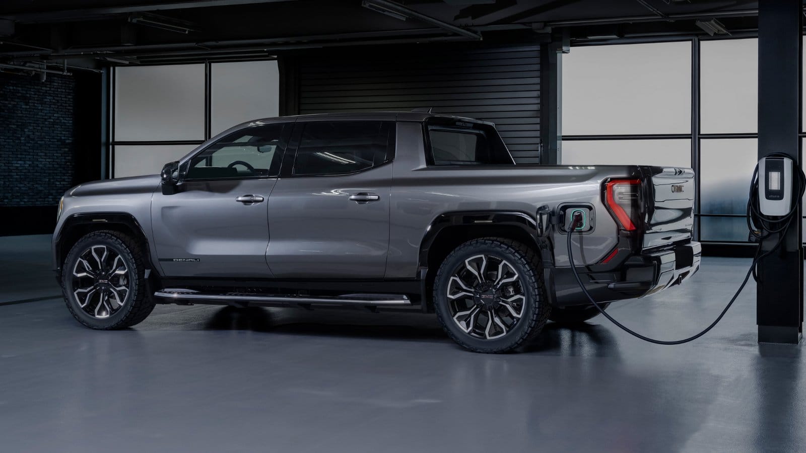 GMC Sierra EV Denali electric vehicle charging indoors via wall-mounted EV charger