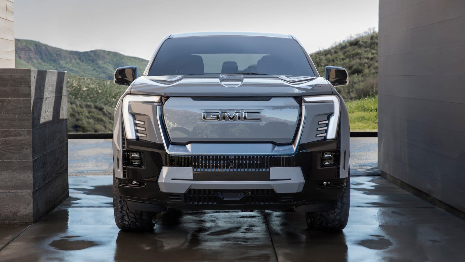 Front view of the GMC Sierra EV Denali electric vehicle showing the illuminated grille and signature LED lighting