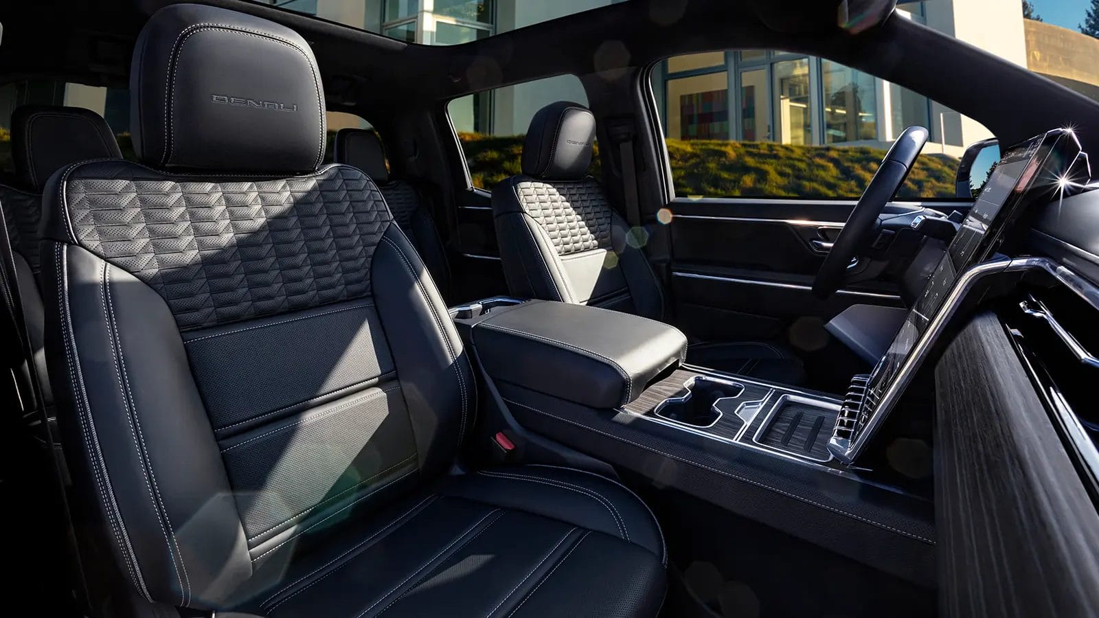 Interior of GMC Sierra EV Denali electric vehicle with quilted leather front seats and touchscreen display