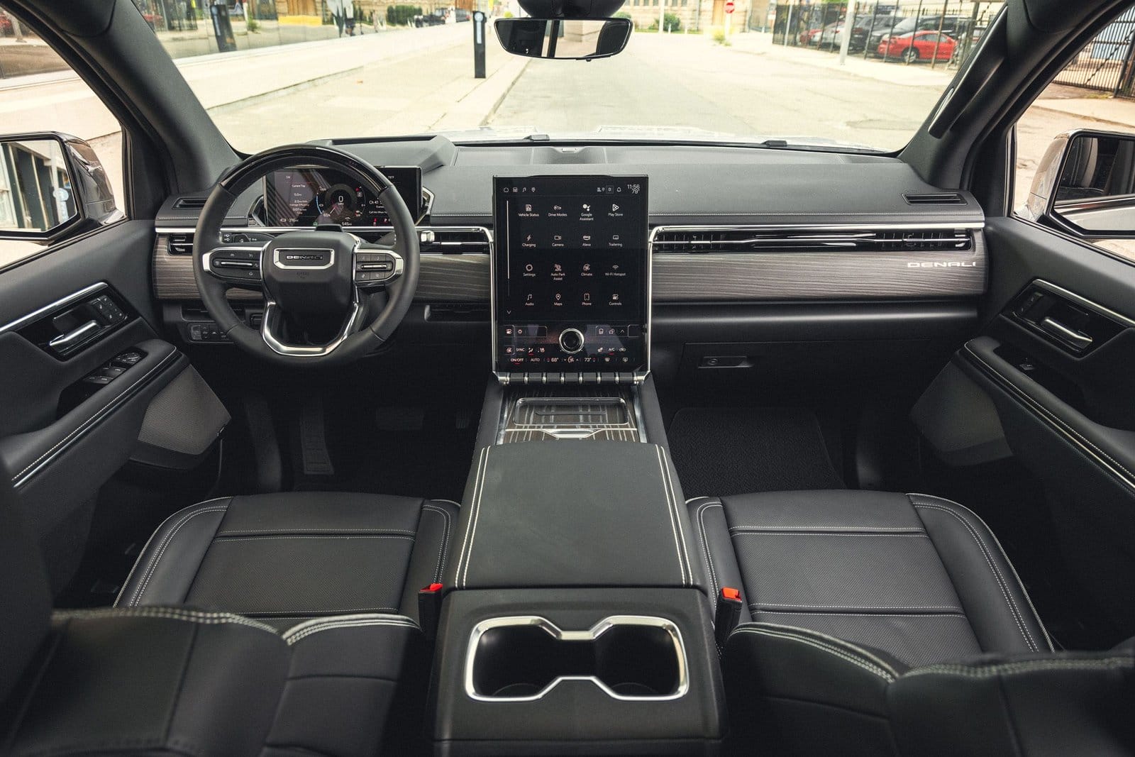 Dashboard and steering wheel view of GMC Sierra EV electric vehicle featuring vertical touchscreen and Denali trim