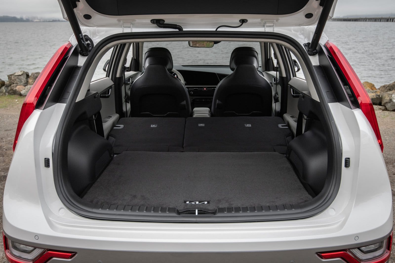 Cargo area of the Kia Niro EV electric vehicle with rear seats folded flat viewed from the open tailgate