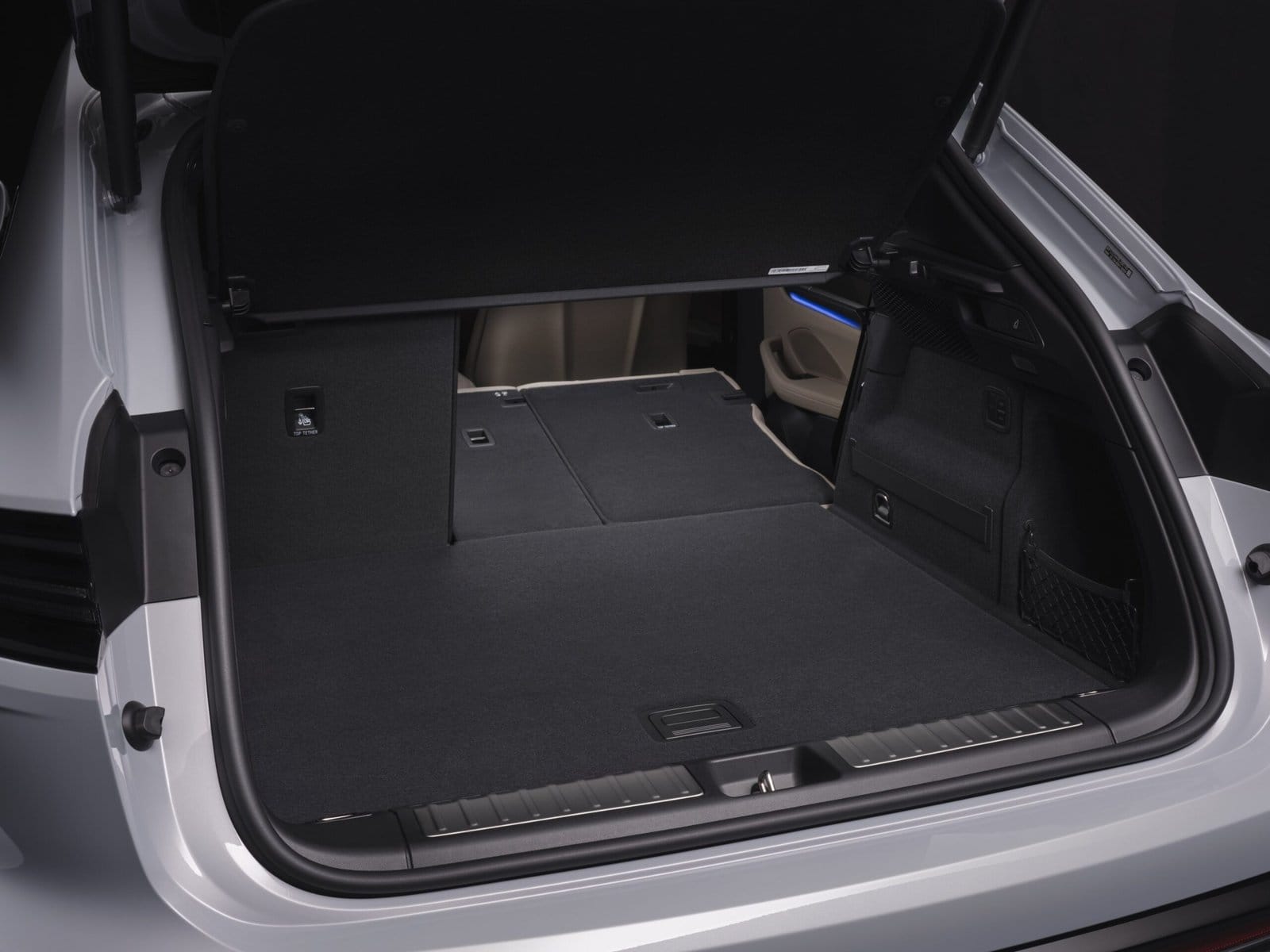 Rear cargo area of the Porsche Macan EV electric vehicle with rear seats folded flat, showing expanded storage space