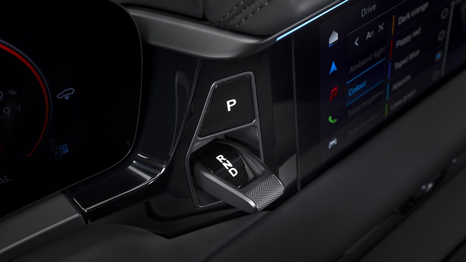 Close-up of the Porsche Macan EV electric vehicle’s gear selector showing reverse, neutral, and drive positions next to digital display menu