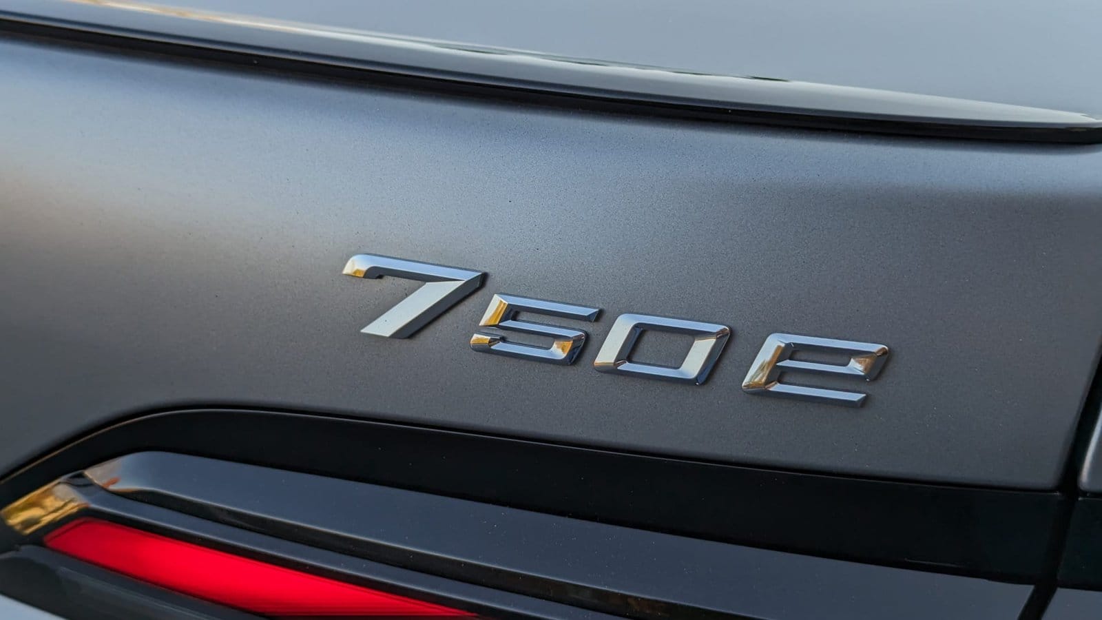 Close-up view of the 750e badge on a BMW 750e xDrive electric vehicle in matte silver