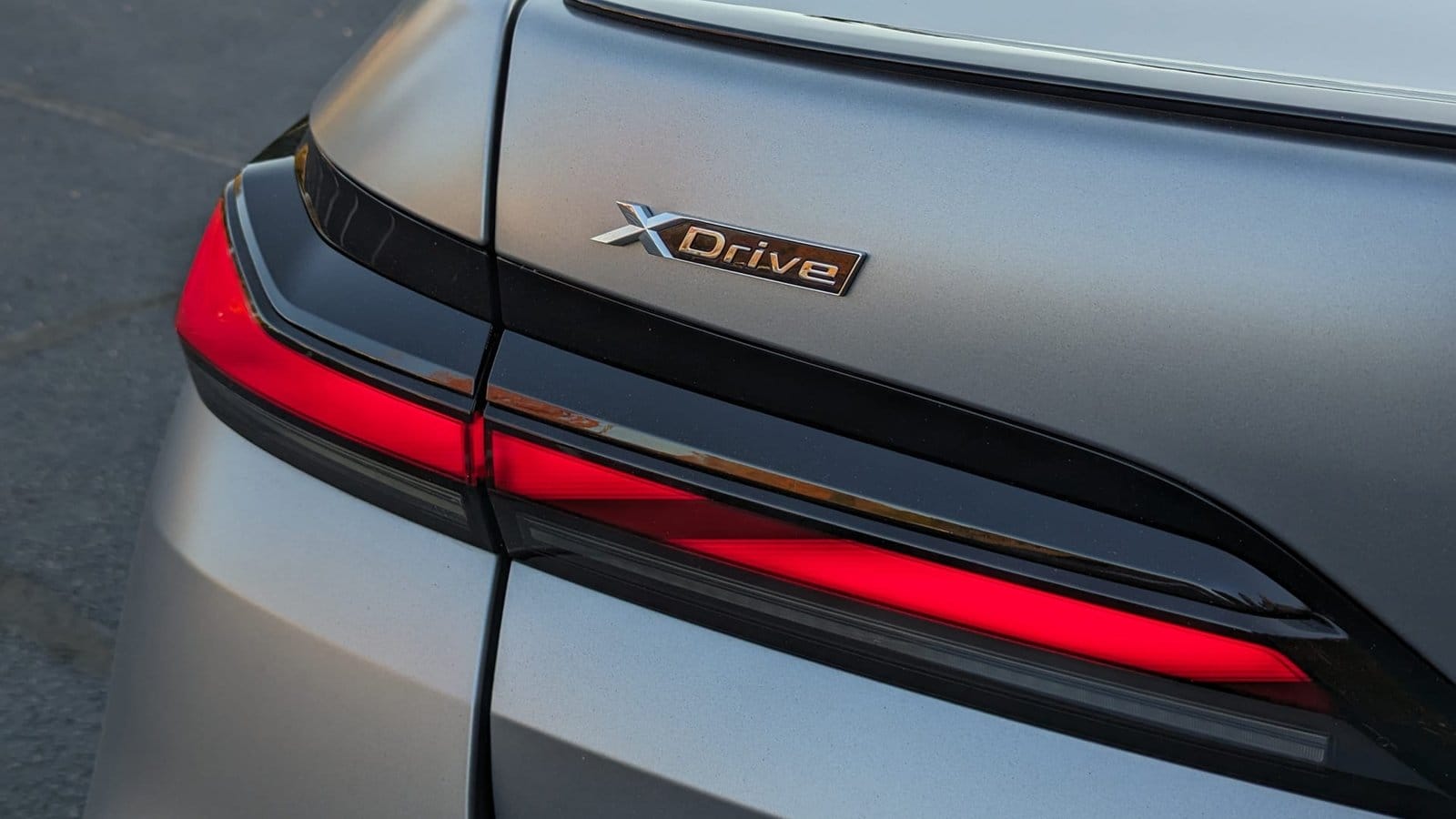Close-up of the xDrive badge and taillight on the BMW 750e xDrive electric vehicle in matte silver