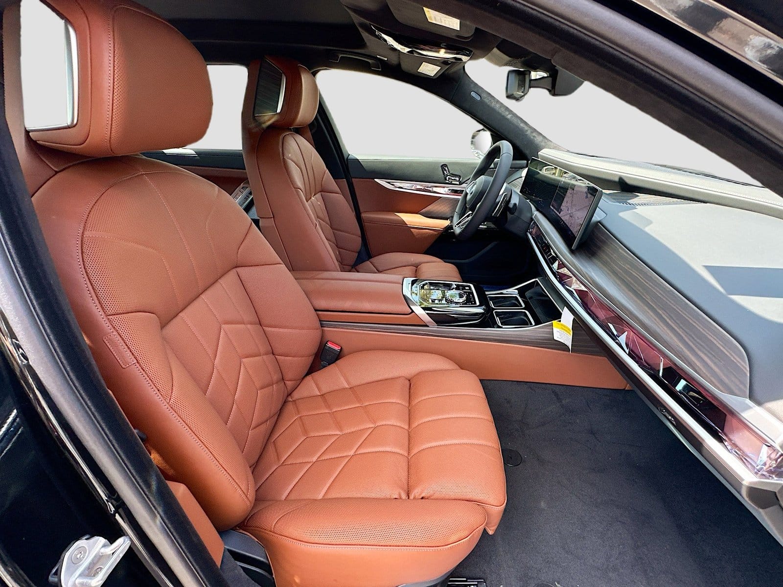 Interior view of the front cabin in a BMW 750e xDrive Plug-in Hybrid showing tan leather seats and dashboard