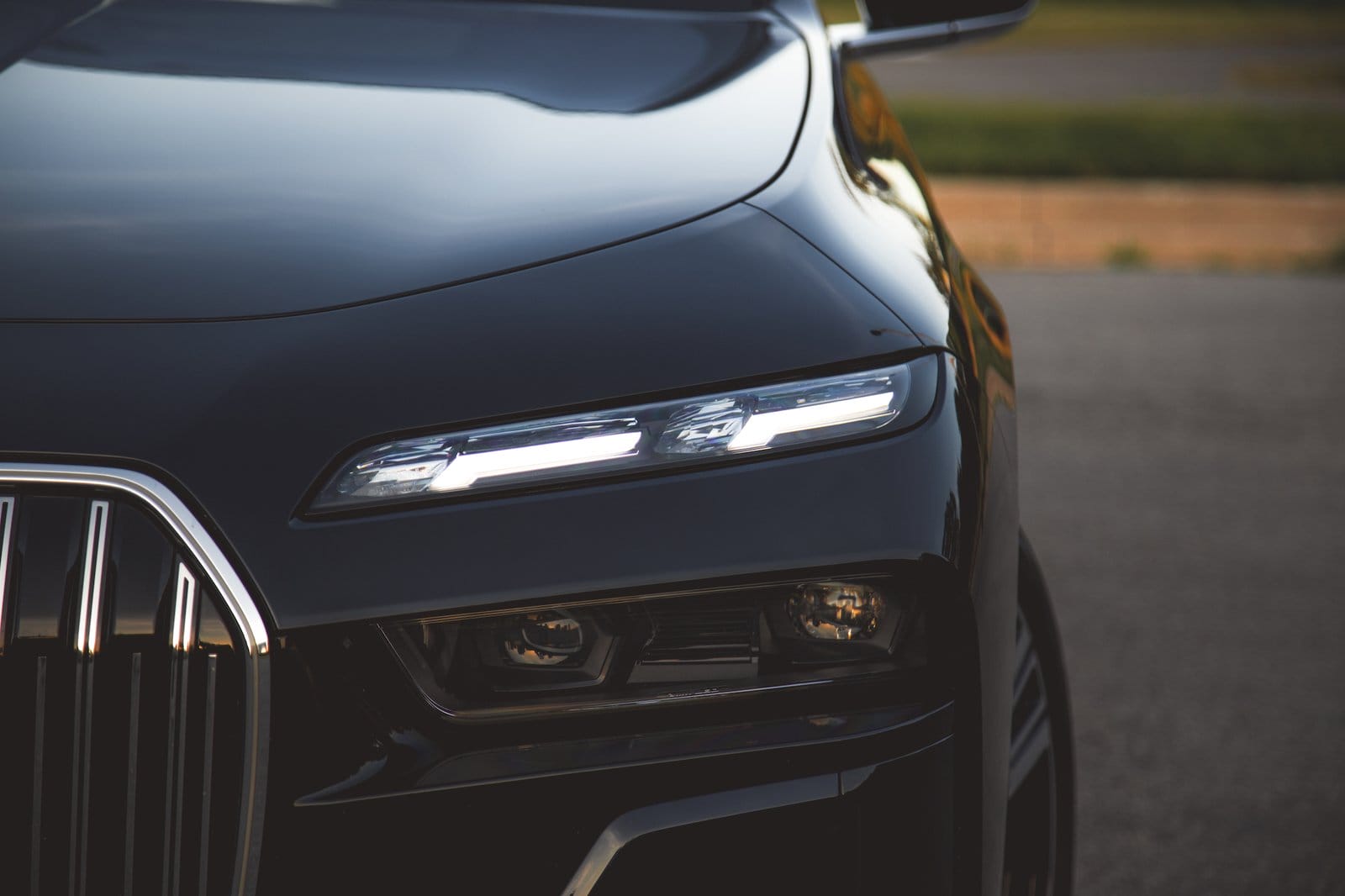 Close-up view of the illuminated LED headlight on the BMW 750e xDrive Plug-in Hybrid showing upper and lower lighting elements