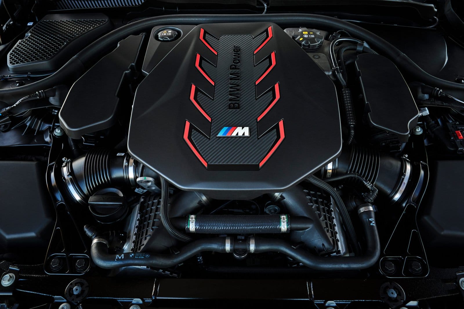 Top view of the BMW M5 Touring Plug-in Hybrid engine bay with carbon fiber M Power cover