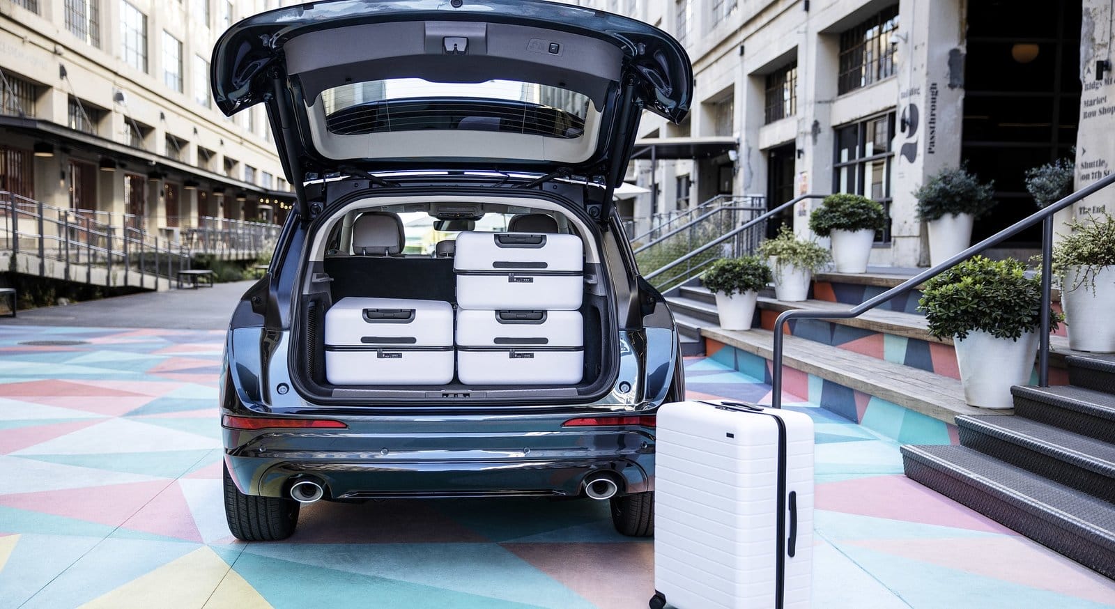 Rear view of Lincoln Corsair electric vehicle with open trunk showing multiple suitcases loaded