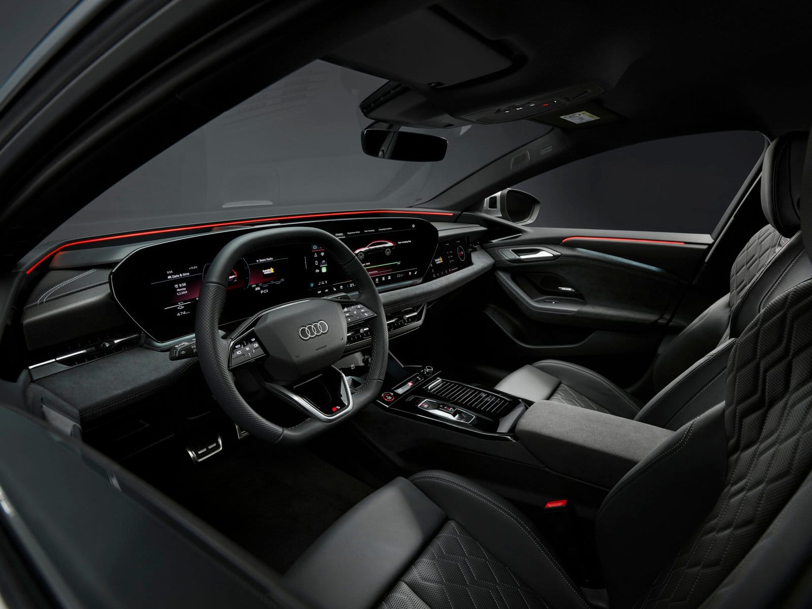 Cockpit view of Audi S6 e-tron electric vehicle showing steering wheel, digital cluster, and front seats.