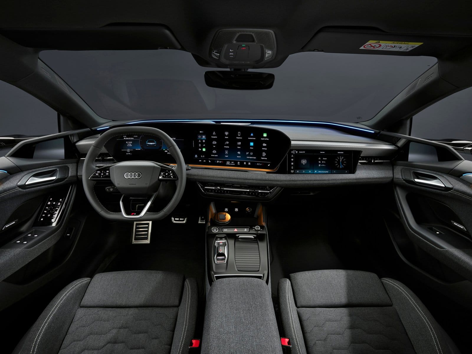 Driver cockpit view of the 2025 Audi A6 e-tron electric vehicle showing steering wheel and dual-screen dashboard