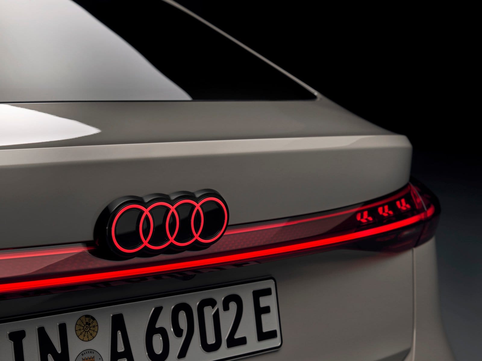 Close-up of the illuminated Audi logo and LED light bar on the 2025 Audi A6 e-tron electric vehicle