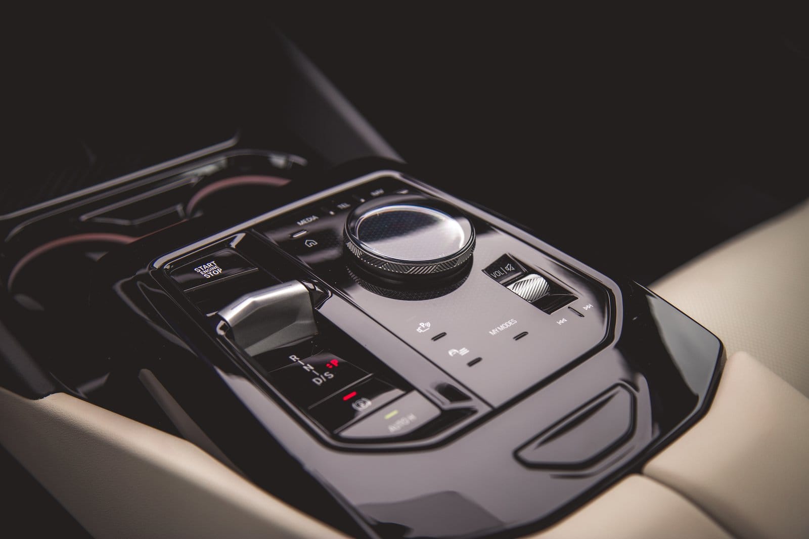 Close-up of BMW 550e xDrive electric vehicle center console with gear selector, start button, and media controls