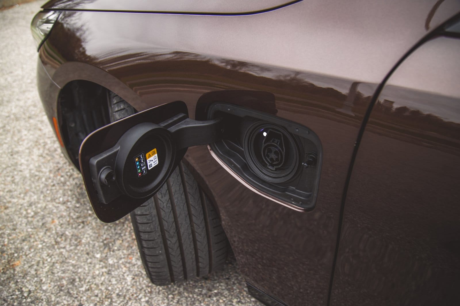 Close-up of BMW 550e xDrive electric vehicle charging port with cover open