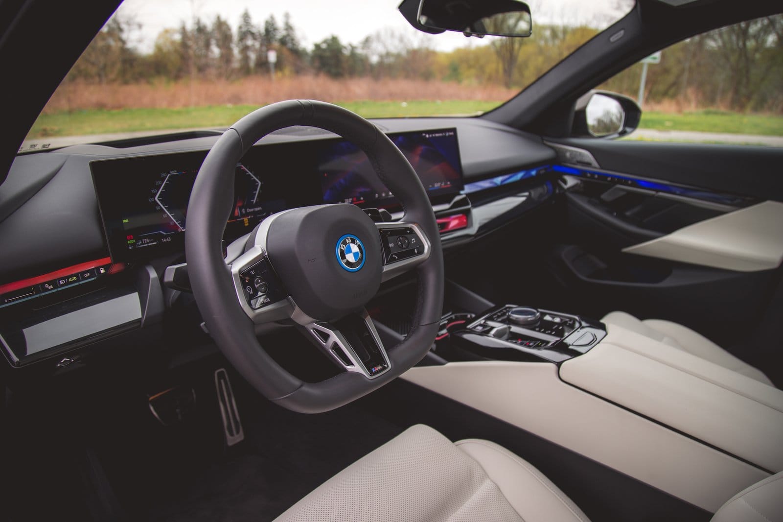 Interior view of BMW 550e xDrive electric vehicle showing steering wheel, digital displays, and dashboard layout