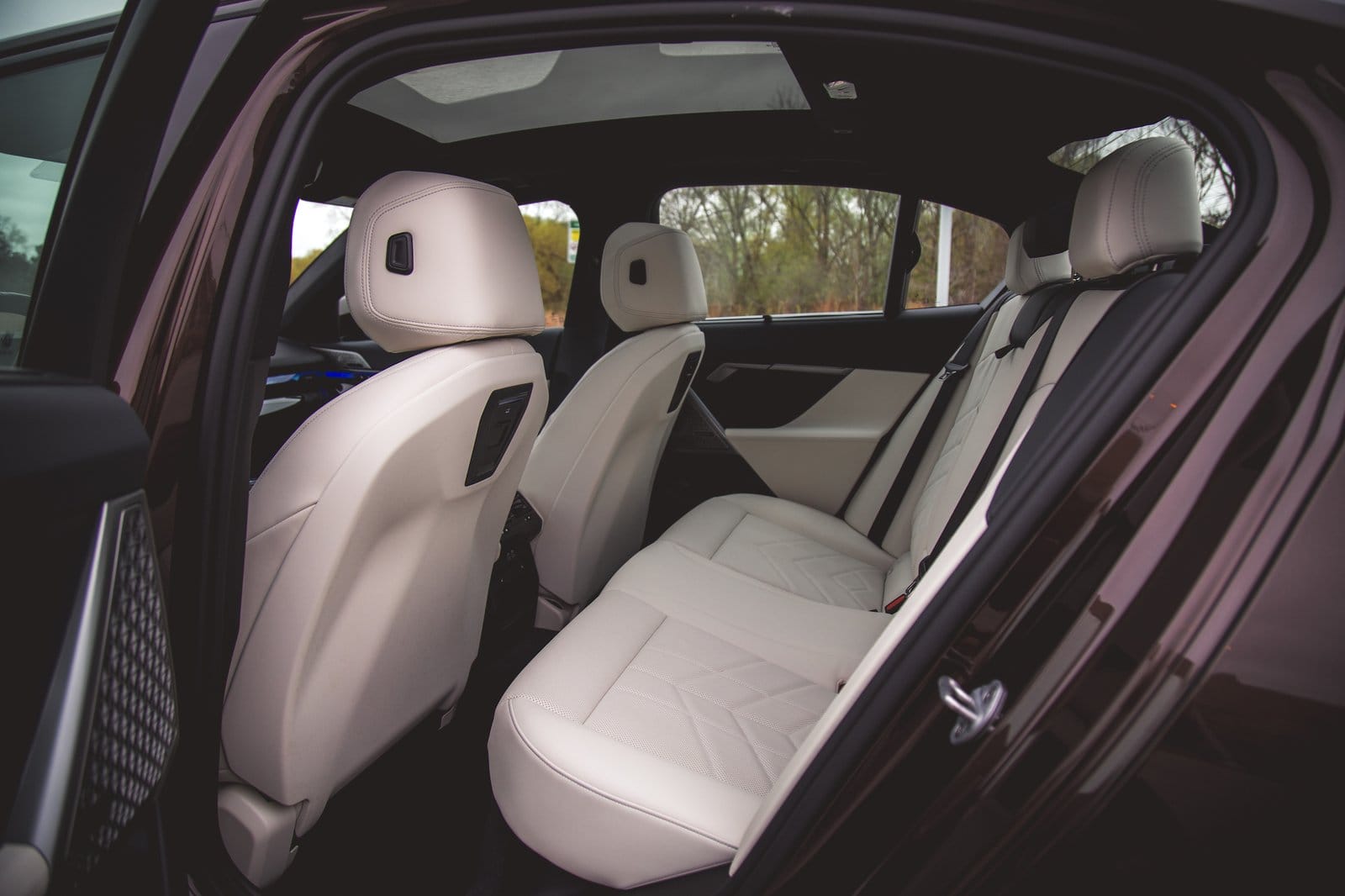 Interior view of BMW 550e xDrive electric vehicle rear seats with light upholstery