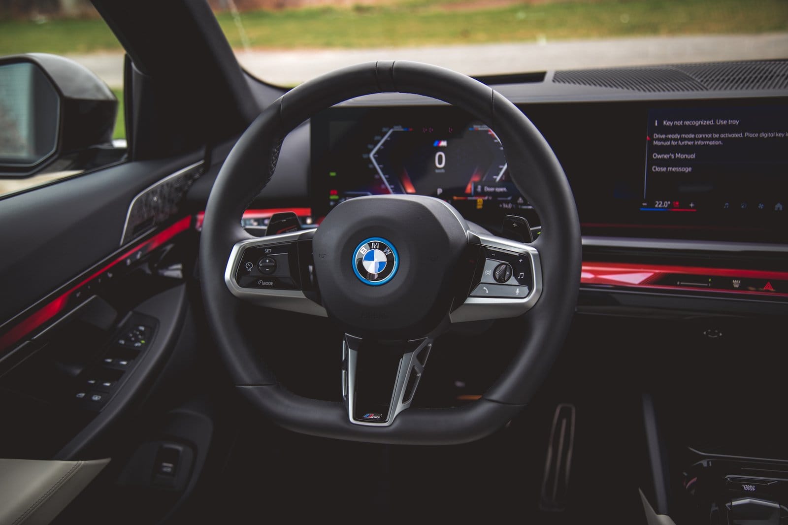 Interior view of BMW 550e xDrive electric vehicle showing steering wheel with digital display in the background