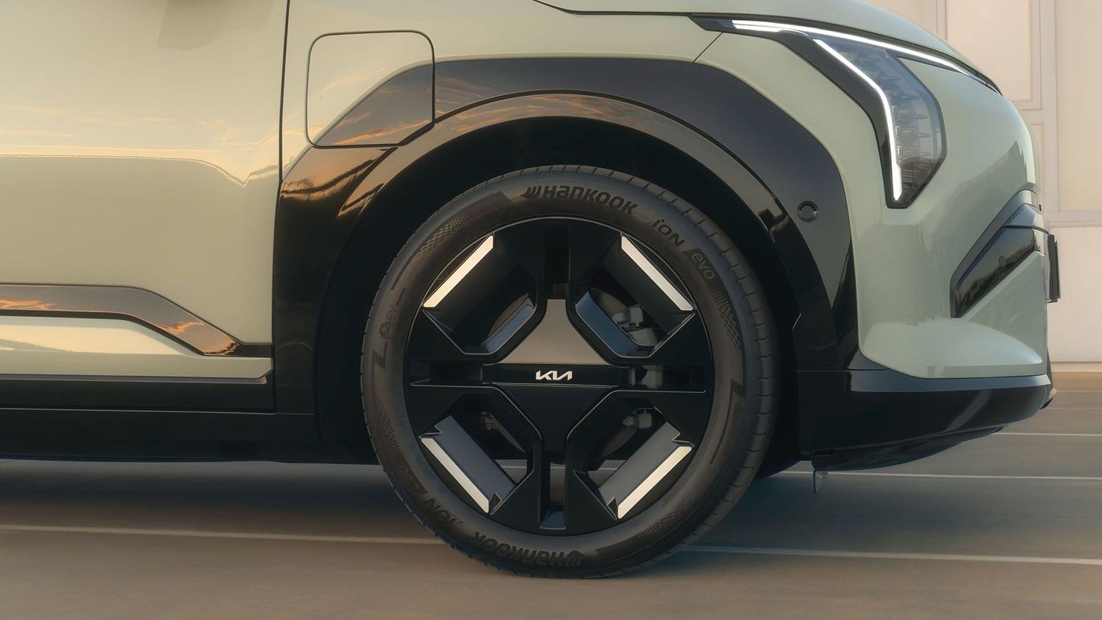 Front wheel detail of Kia EV3 electric vehicle showing black alloy design and Hankook tire.
