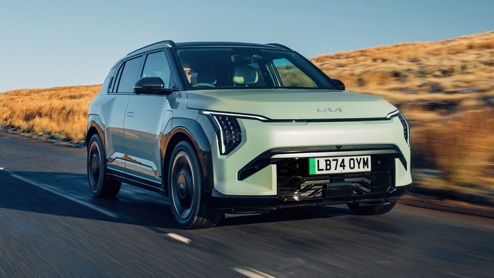 Kia EV3 electric vehicle driving on a countryside road