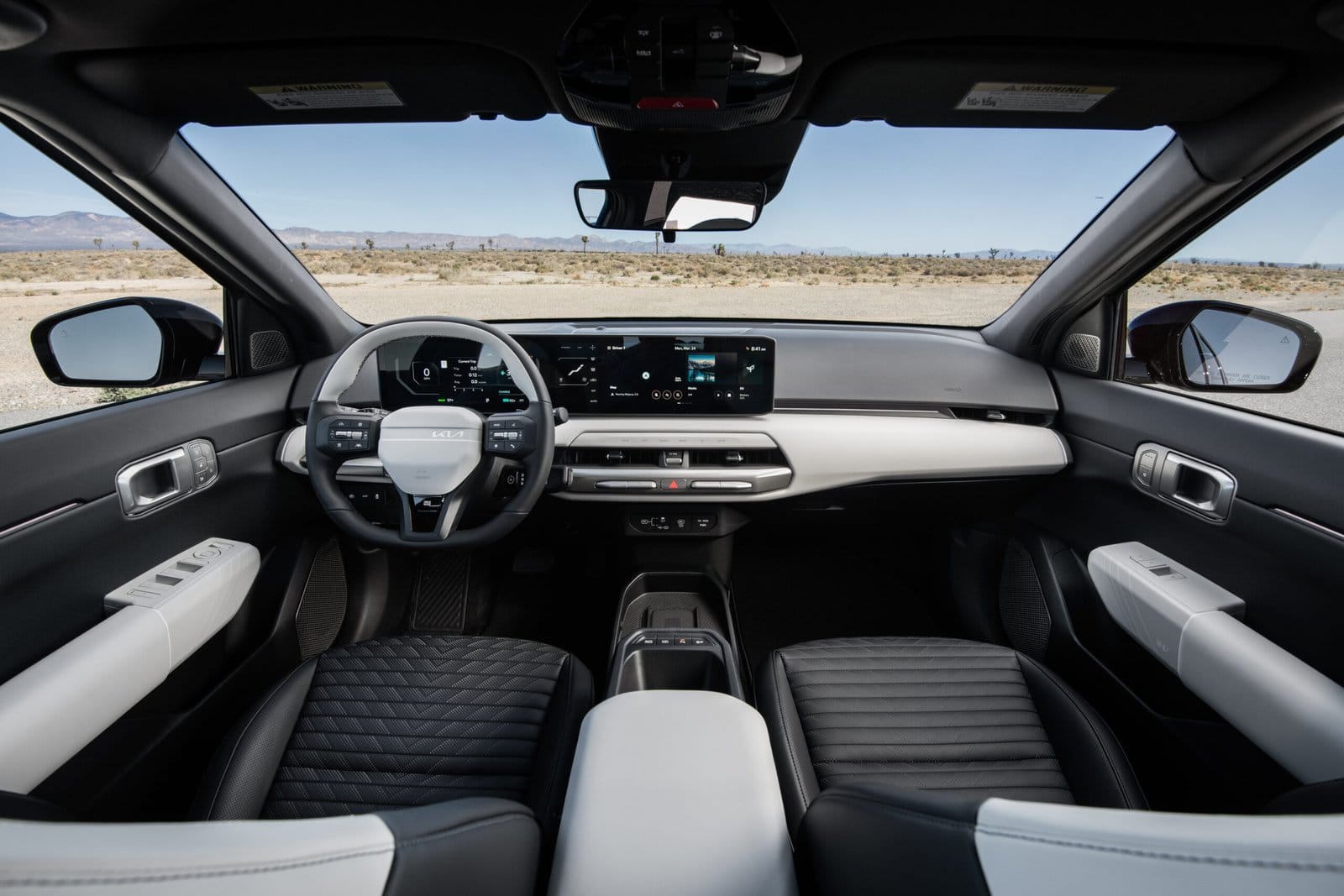 Interior of Kia EV4 electric vehicle showing dashboard, steering wheel, and front seats with digital displays