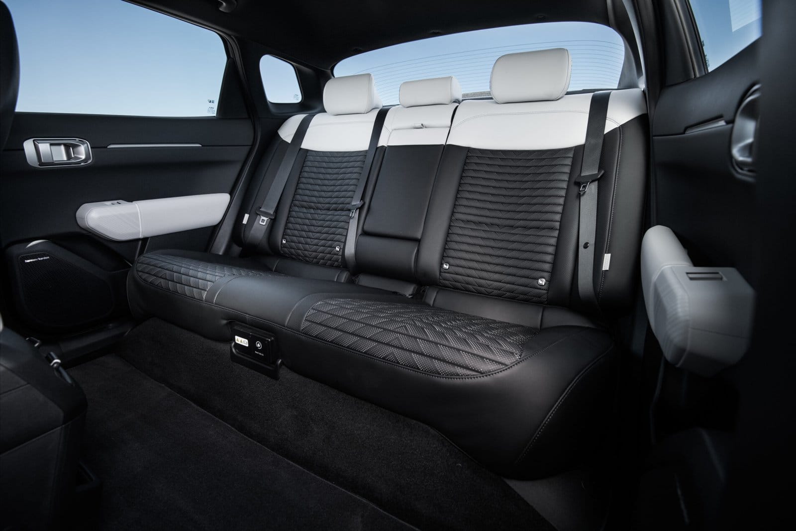 Rear seating view of Kia EV4 electric vehicle showing three seats with black and white quilted upholstery