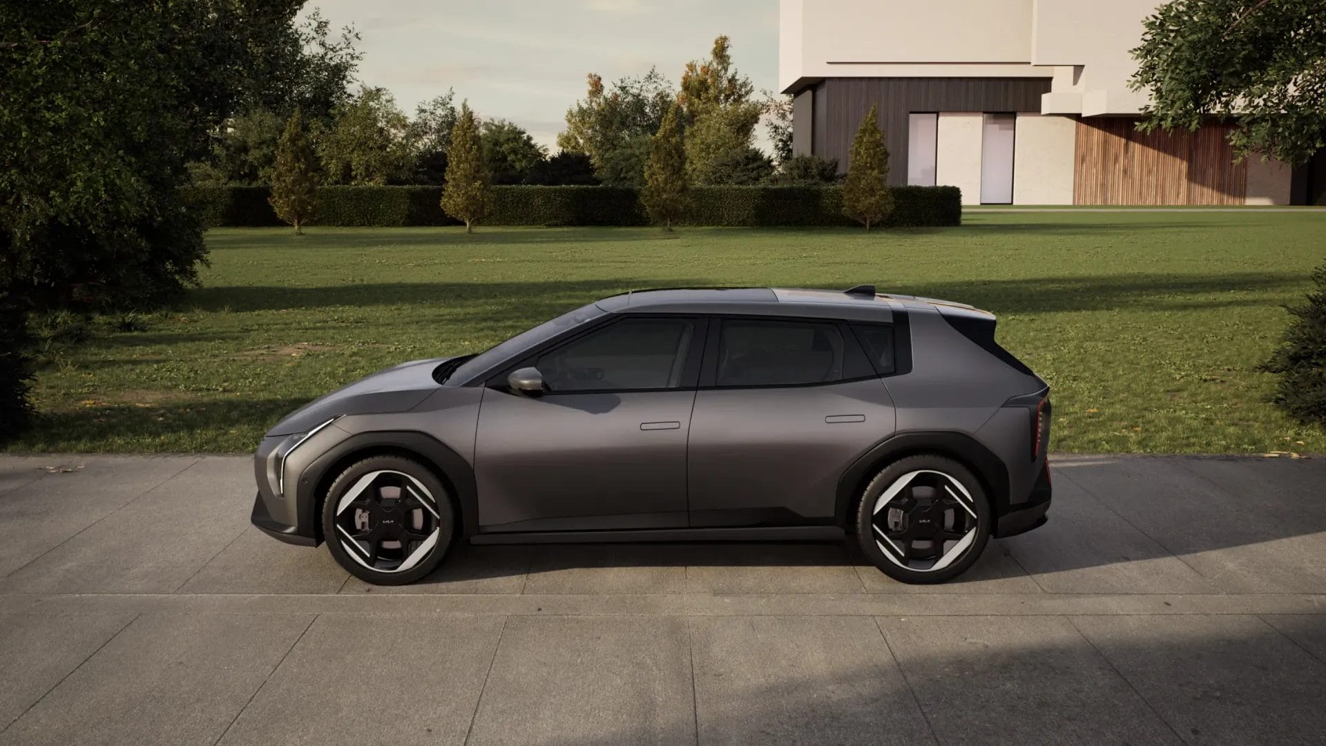 Side view of Kia EV4 electric vehicle parked on a driveway with a house and trees in the background