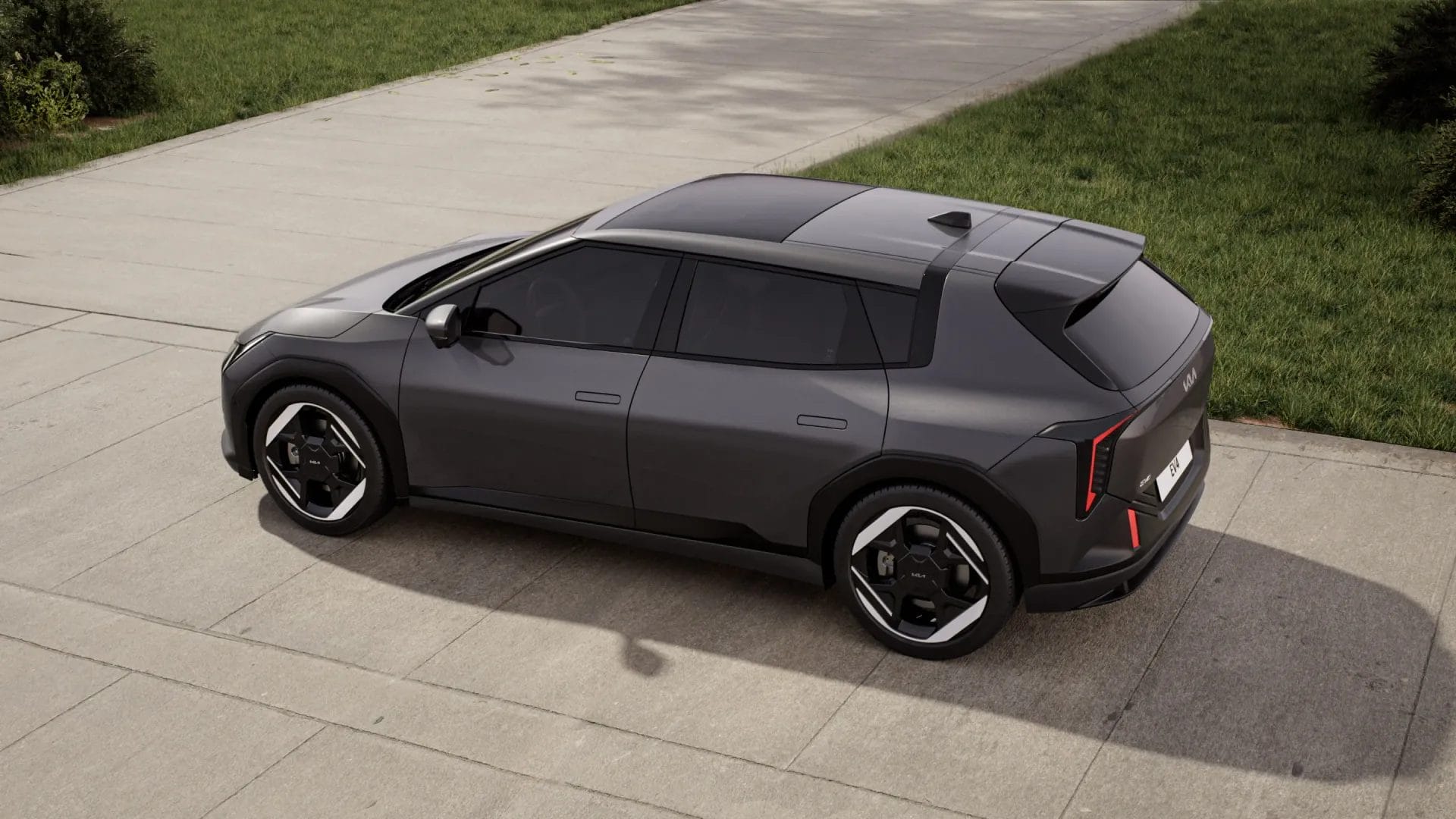 Top rear angle of Kia EV4 electric vehicle parked on a concrete driveway with green grass in the background